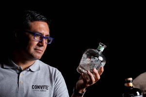 Dr. Jorge Vera holding a bottle of Convite